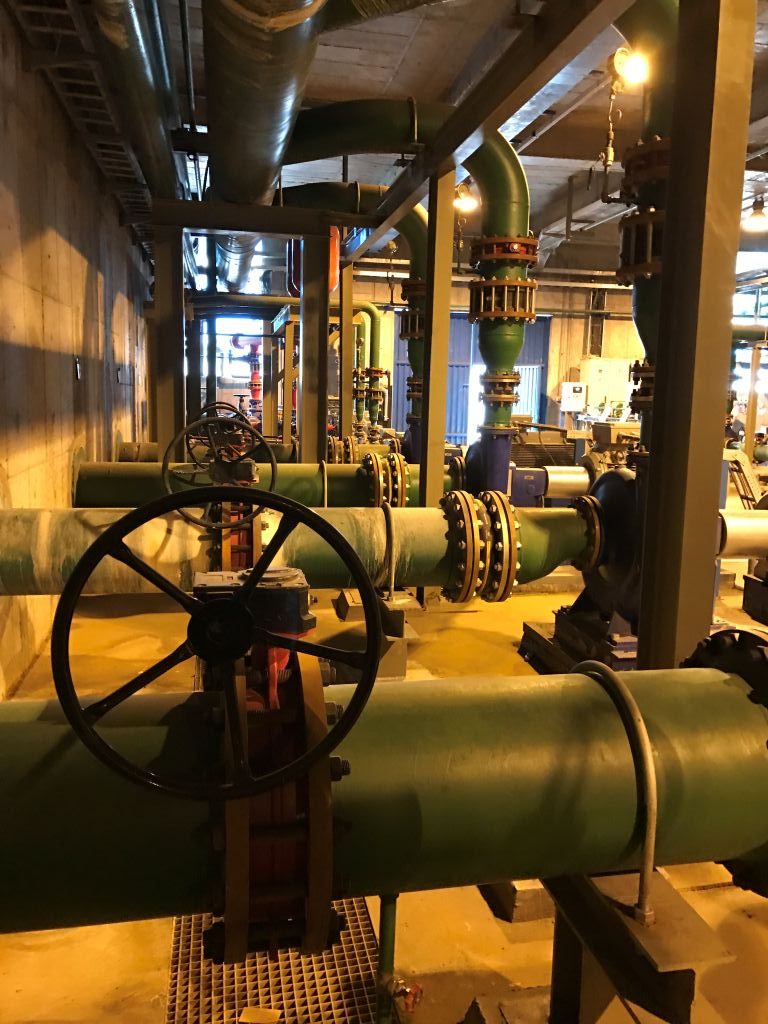 Industrial pipework and a hand-operated valve inside a plant